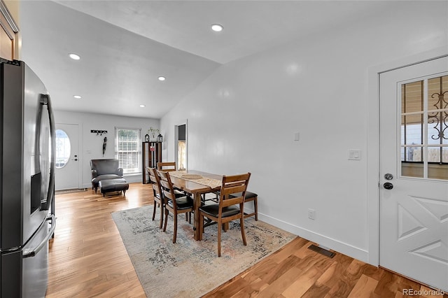 dining room with light hardwood / wood-style flooring and lofted ceiling