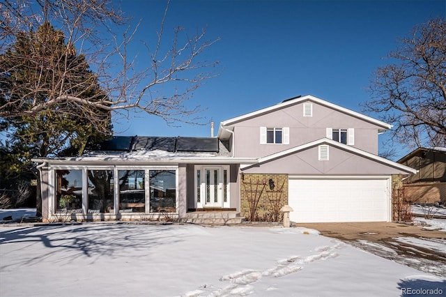 view of front of house with a garage and solar panels