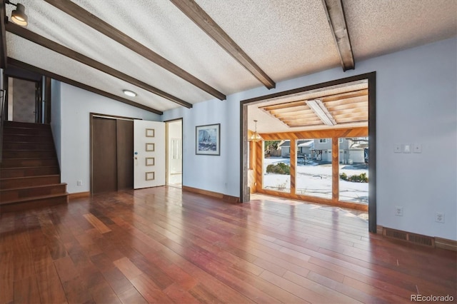 unfurnished living room featuring elevator, lofted ceiling with beams, dark hardwood / wood-style floors, and a textured ceiling