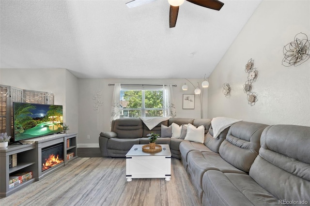 3965 S Fundy Cir, Aurora, CO 80013 - living area featuring wood finished floors, ceiling fan, a textured ceiling, and a glass covered fireplace