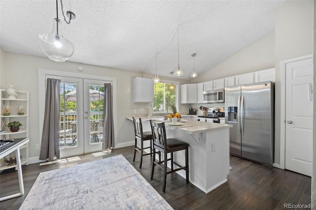 3965 S Fundy Cir, Aurora, CO 80013 - kitchen featuring appliances with stainless steel finishes, a textured ceiling, white cabinetry, a kitchen bar, and dark wood finished floors