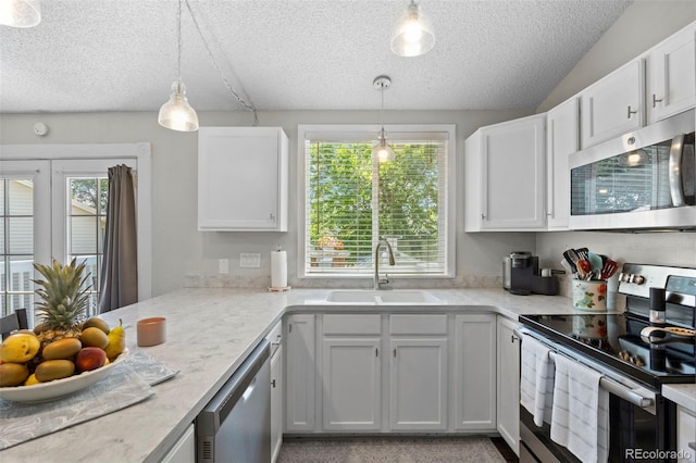 3965 S Fundy Cir, Aurora, CO 80013 - kitchen featuring appliances with stainless steel finishes, a textured ceiling, light countertops, hanging light fixtures, and white cabinets