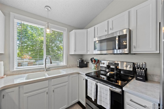 3965 S Fundy Cir, Aurora, CO 80013 - kitchen featuring appliances with stainless steel finishes, a textured ceiling, white cabinetry, light countertops, and vaulted ceiling