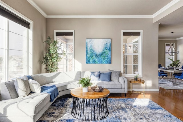 living room featuring crown molding, plenty of natural light, hardwood / wood-style floors, and an inviting chandelier