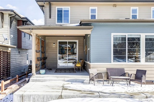 snow covered property entrance with a patio area