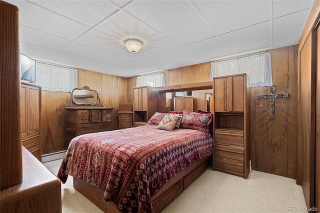 5960 Glencoe St, Commerce City, CO 80022 - carpeted bedroom with wood walls, multiple windows, and a baseboard radiator