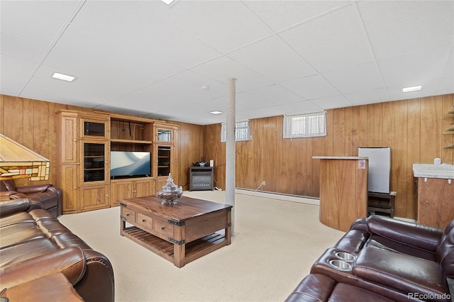 5960 Glencoe St, Commerce City, CO 80022 - living room featuring wooden walls, a paneled ceiling, carpet floors, and a baseboard heating unit