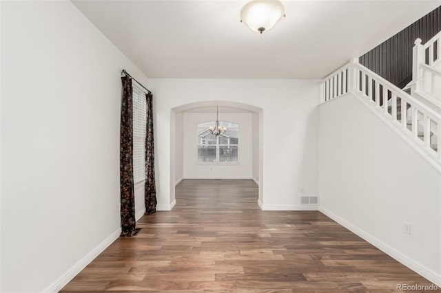 hall featuring dark hardwood / wood-style flooring and a chandelier