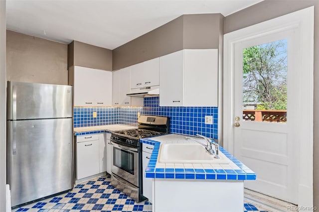 1352 N Downing St, Denver, CO 80218 - kitchen featuring stainless steel appliances, under cabinet range hood, white cabinets, and tasteful backsplash