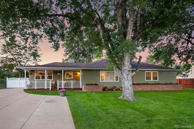 single story home with covered porch and a yard