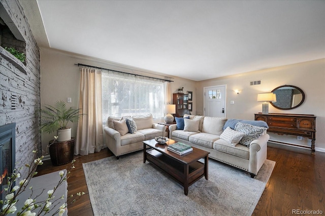 living room with a fireplace and dark wood-type flooring