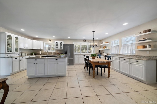 kitchen with decorative light fixtures, white cabinetry, a center island, and high end fridge