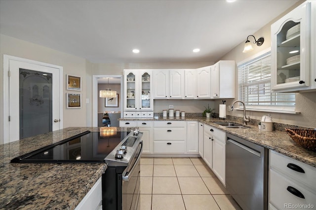 kitchen featuring white cabinets, stainless steel appliances, dark stone counters, and sink