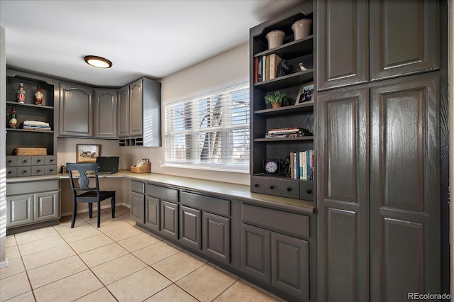 office with light tile patterned floors and built in desk