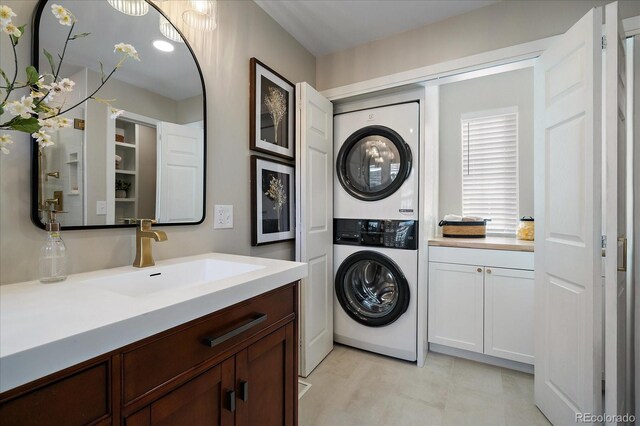 clothes washing area with sink and stacked washing maching and dryer