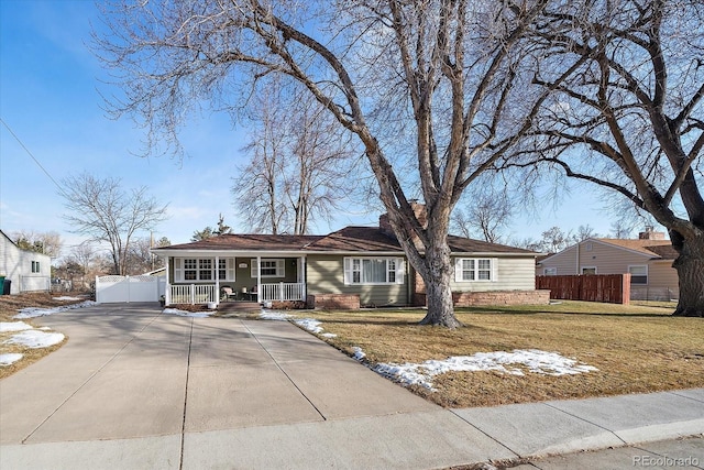 ranch-style house with a porch and a front lawn