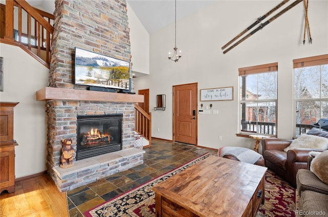 living room with wood-type flooring, a fireplace, high vaulted ceiling, and a chandelier