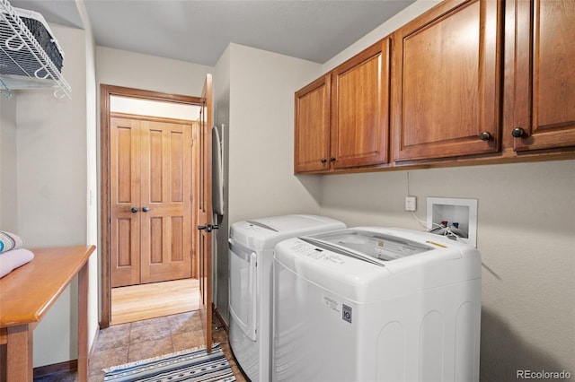 laundry area with light hardwood / wood-style floors, cabinets, and separate washer and dryer