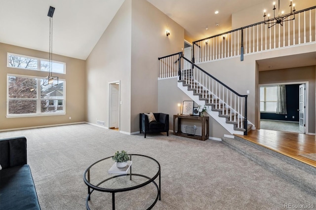 carpeted living room with plenty of natural light, a high ceiling, stairway, and baseboards