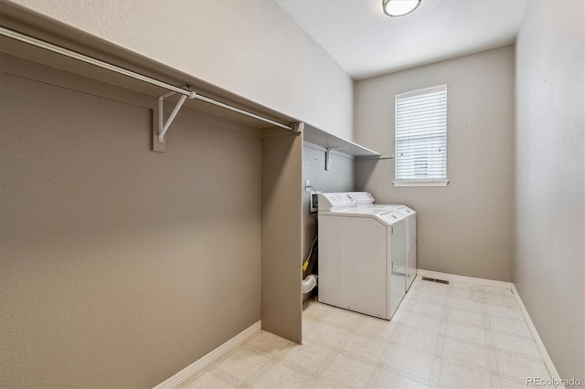 clothes washing area featuring washing machine and dryer, laundry area, visible vents, baseboards, and light floors