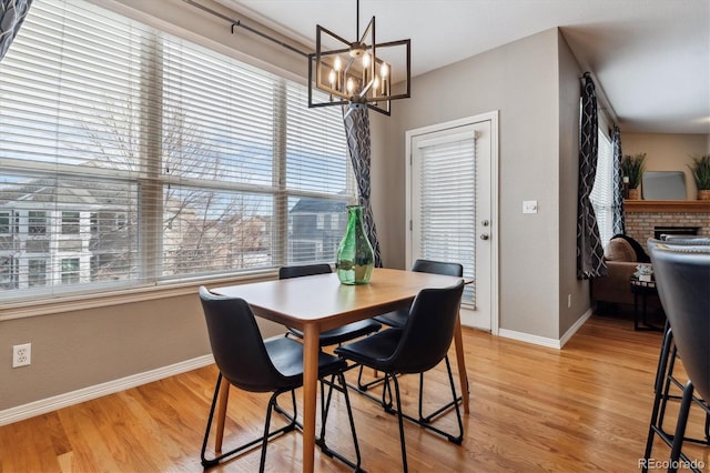 dining space with light wood finished floors, baseboards, and a notable chandelier