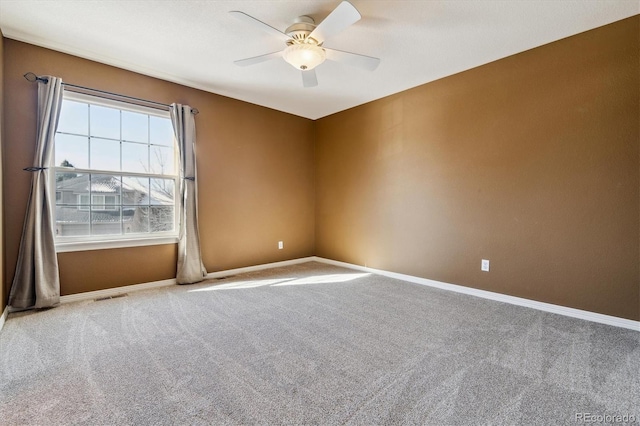 carpeted spare room with ceiling fan, visible vents, and baseboards