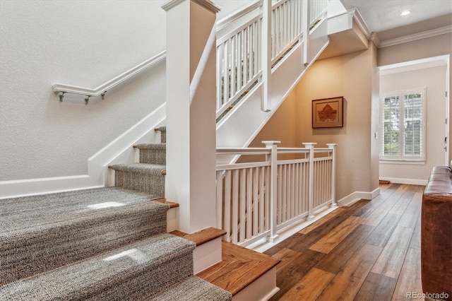 stairway featuring hardwood / wood-style flooring and crown molding