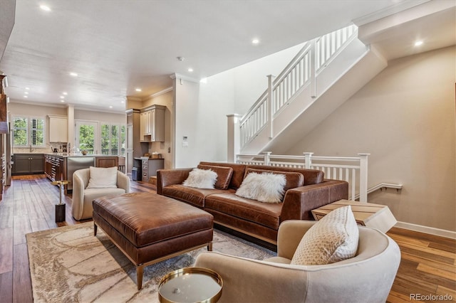 living room with crown molding and light hardwood / wood-style flooring