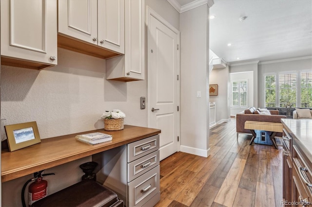 kitchen featuring white cabinets, light hardwood / wood-style flooring, and crown molding