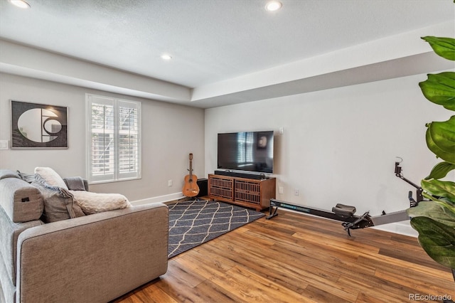 living room with wood-type flooring and a textured ceiling