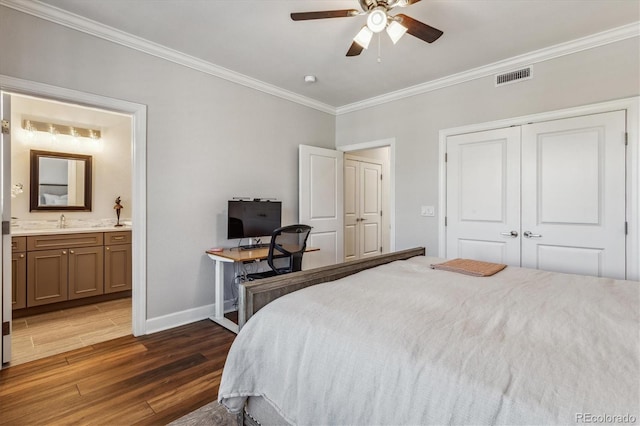 bedroom featuring ceiling fan, crown molding, sink, dark hardwood / wood-style floors, and a closet