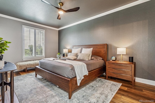 bedroom featuring dark hardwood / wood-style floors, ceiling fan, ornamental molding, and a textured ceiling