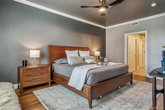 bedroom featuring ceiling fan, crown molding, and wood-type flooring