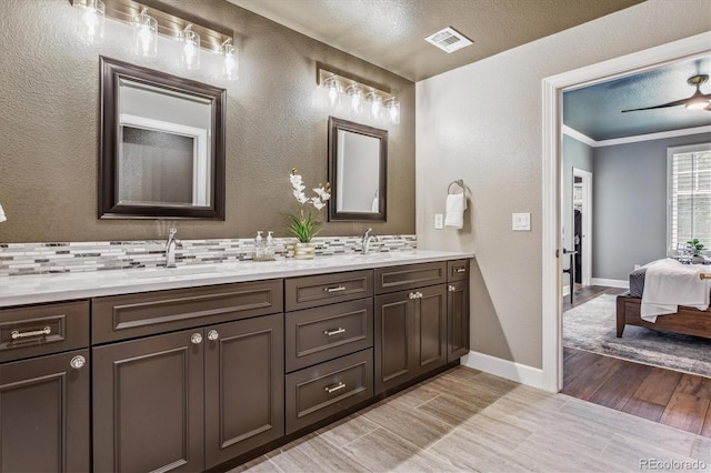 bathroom with vanity, hardwood / wood-style flooring, decorative backsplash, ornamental molding, and a textured ceiling