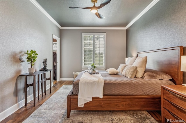 bedroom with ceiling fan, hardwood / wood-style floors, crown molding, and a textured ceiling