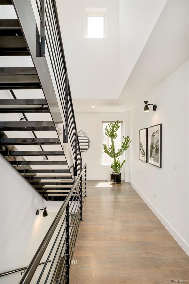 stairway with baseboards and wood finished floors