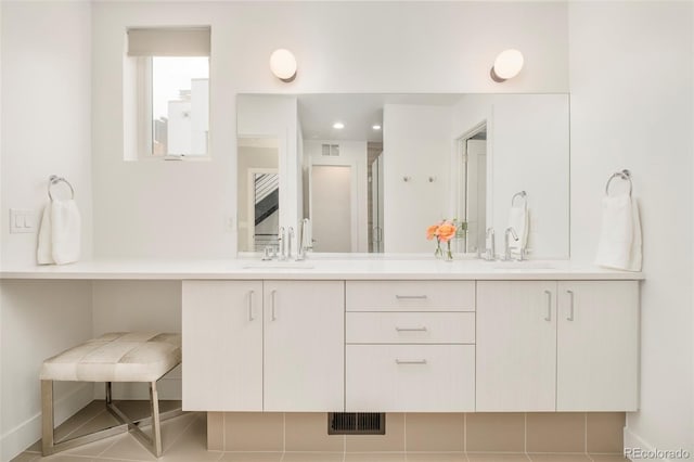 bathroom with double vanity, a sink, and visible vents