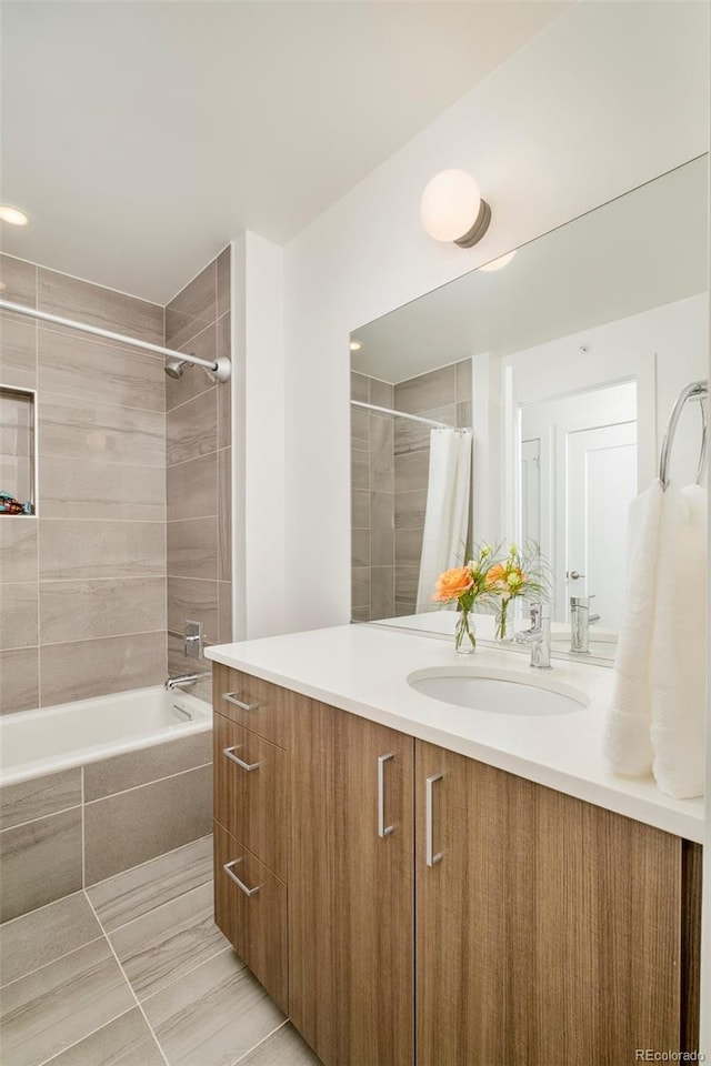 full bath featuring vanity and tiled shower / bath combo