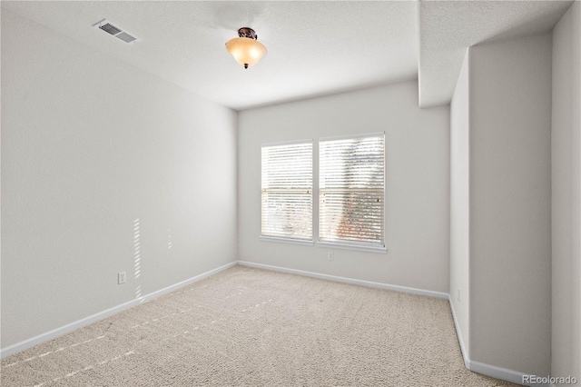 carpeted empty room with a textured ceiling