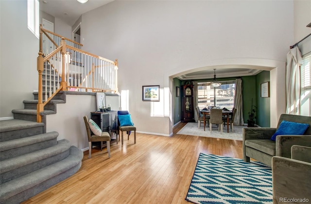 living room featuring a towering ceiling and hardwood / wood-style flooring