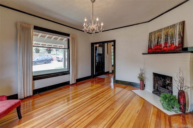 114 Cave Ave, Manitou Springs, CO 80829 - unfurnished living room with wood finished floors, a chandelier, a fireplace with flush hearth, and baseboards