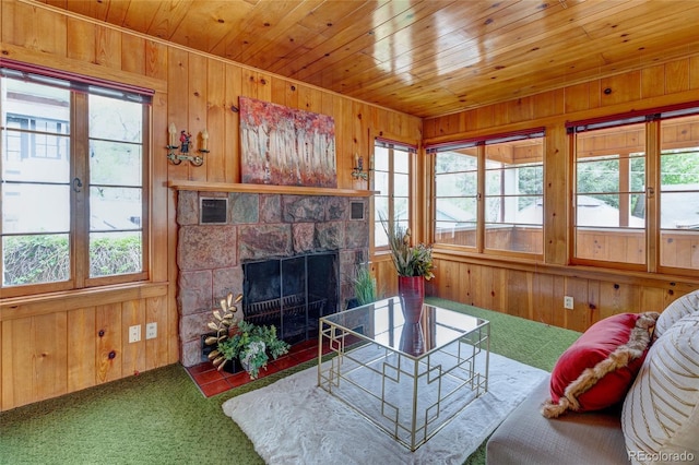 114 Cave Ave, Manitou Springs, CO 80829 - carpeted living area featuring wood walls, a stone fireplace, and wood ceiling