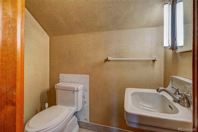 114 Cave Ave, Manitou Springs, CO 80829 - bathroom with a sink, toilet, vaulted ceiling, and tile patterned floors