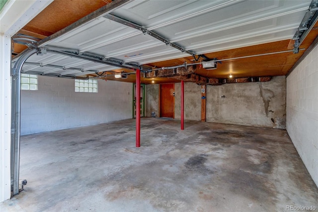 114 Cave Ave, Manitou Springs, CO 80829 - garage featuring a garage door opener and concrete block wall