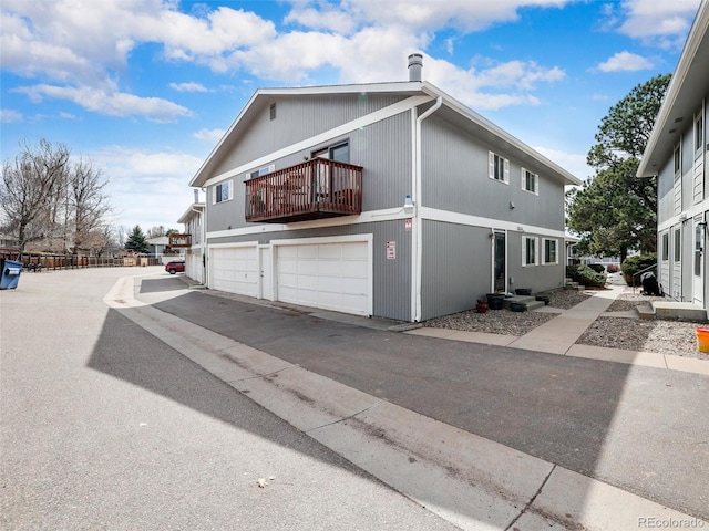 view of side of home with an attached garage and a balcony