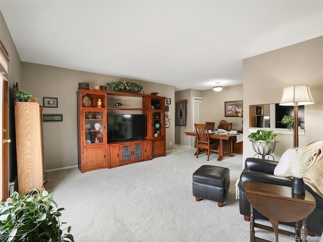 living room with baseboards and light carpet