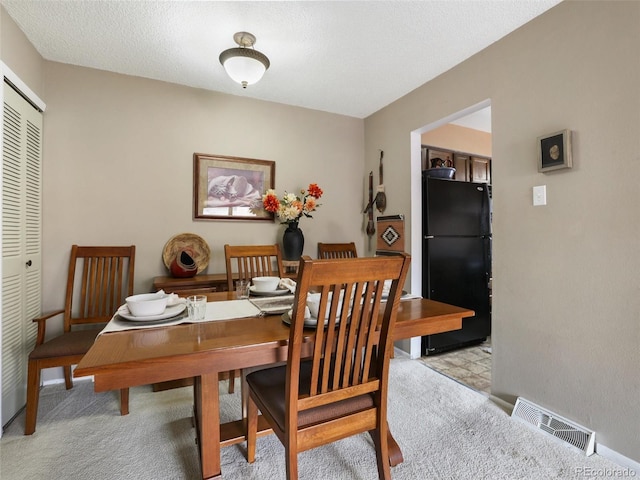 dining room with visible vents and light carpet