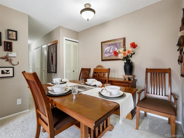 carpeted dining room featuring baseboards