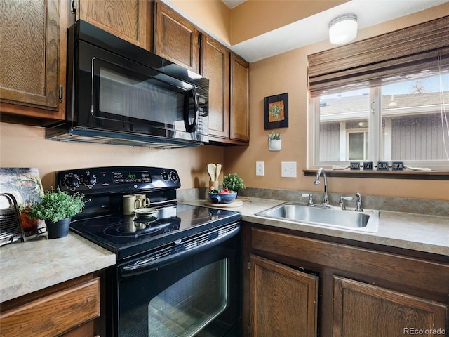 kitchen with black appliances, light countertops, and a sink