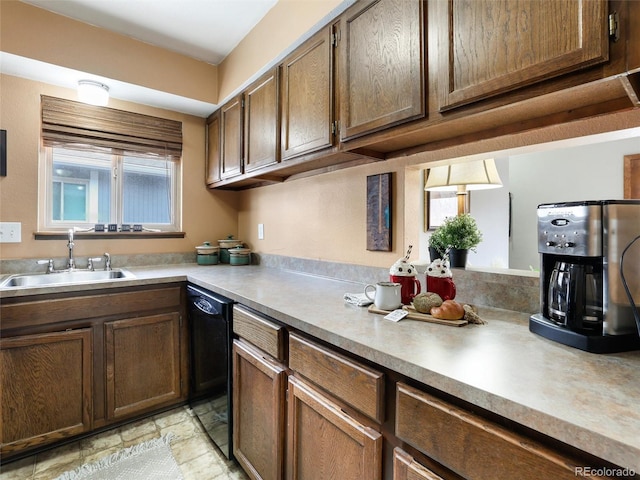 kitchen with dishwasher, light countertops, and a sink